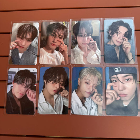 Set of eight photo cards featuring kpop group ateez in various poses on a wooden surface.